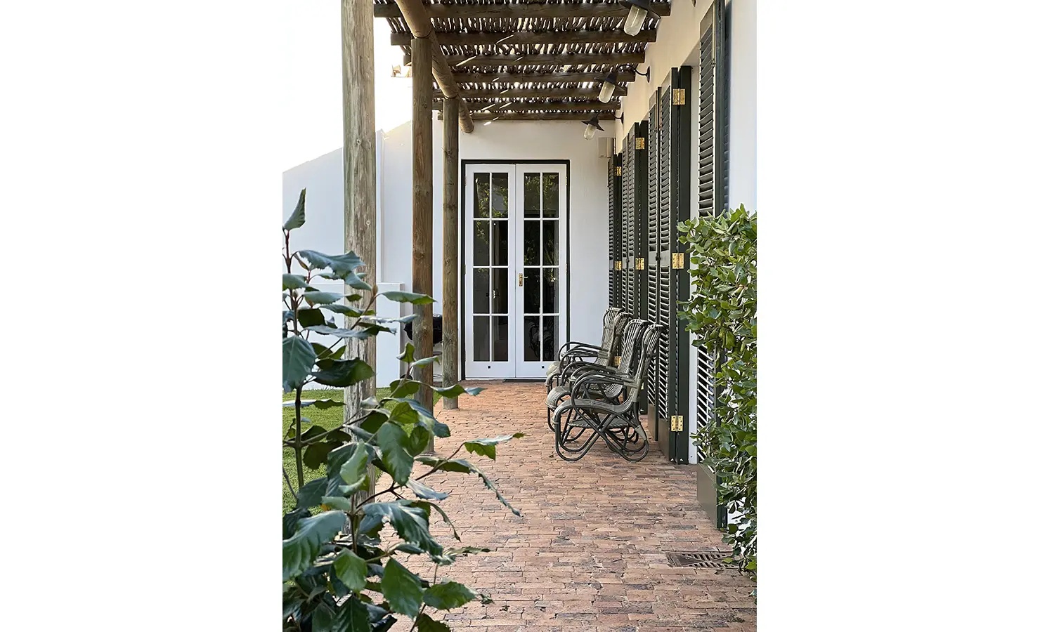 Perfect Hideaways: A brick-paved veranda with rocking chairs and a pergola, bordered by green shrubs. Penhill Manor House, Nuy Valley.