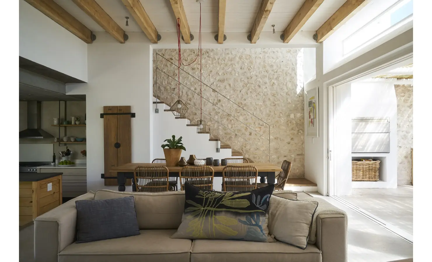 Perfect Hideaways: A beautifully designed open-plan living and dining area featuring exposed wooden beams, a natural stone staircase, and warm rustic decor with soft lighting. Blue Lagoon, Langebaan.