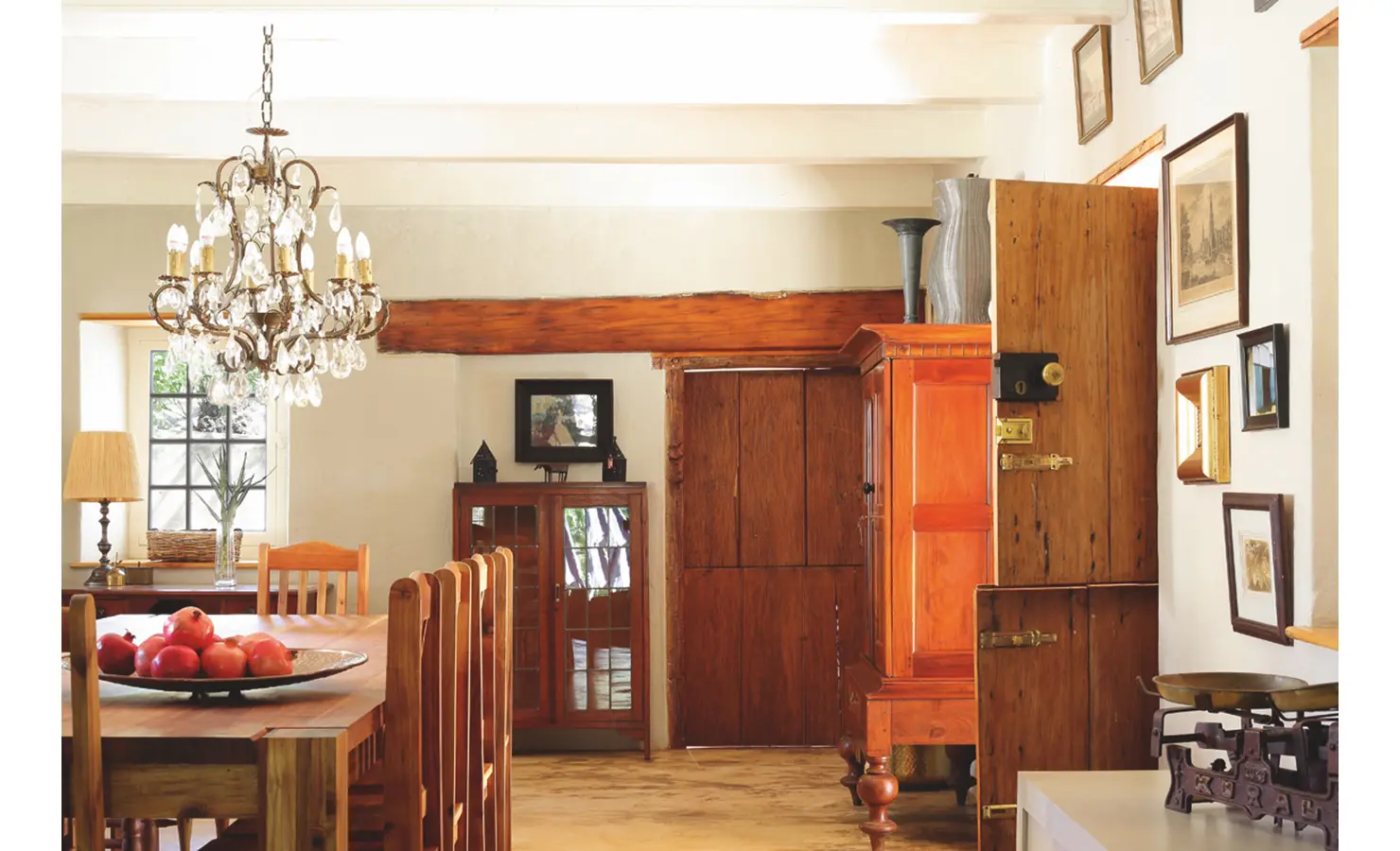 Joubertsdal dining room with a low ceiling and warm wooden touches reflective in the dining table, farm style doors and wooden cabinets.