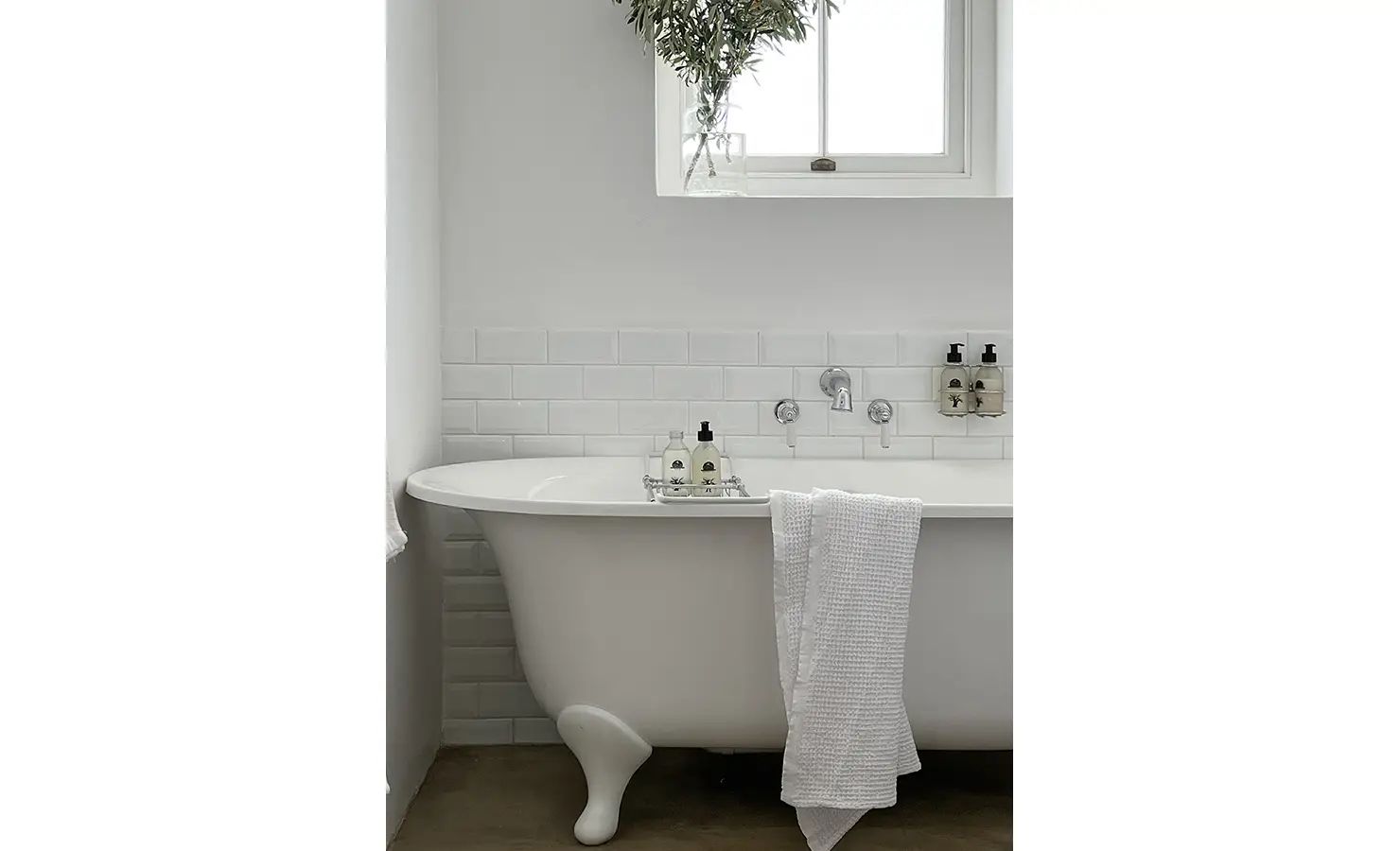 Perfect Hideaways: A charming bathroom featuring a classic freestanding bathtub, white subway tiles, and soft neutral tones. A sprig of olive branches by the window adds a natural, tranquil touch. Penhill Fruit Barn, Nuy Valley.