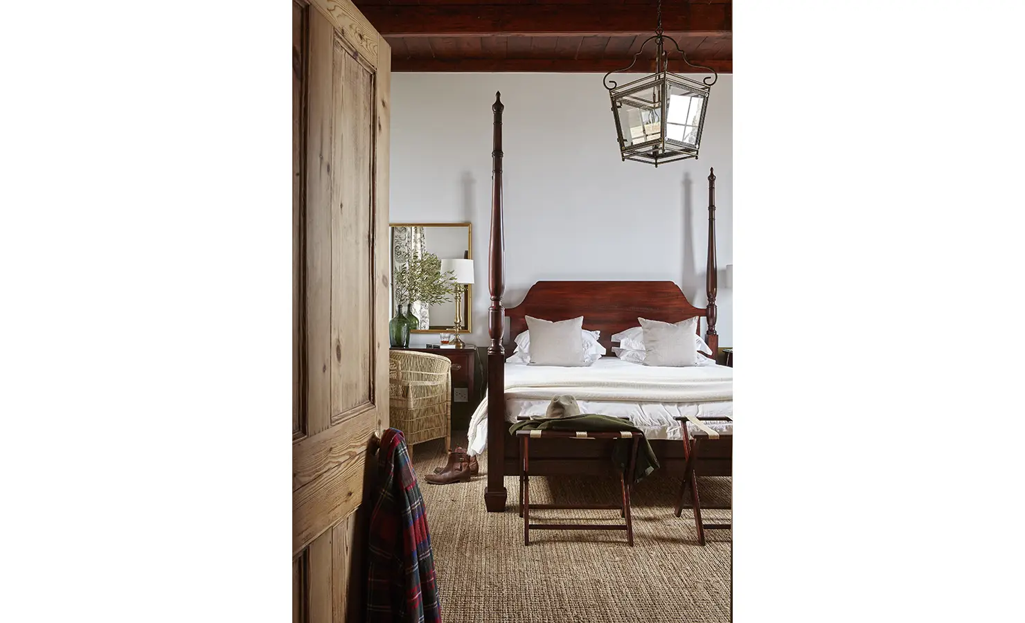 Perfect Hideaways: A serene bedroom with a wooden four-poster bed, rustic decor, and soft lighting under a high wooden ceiling. Penhill Manor House, Nuy Valley.