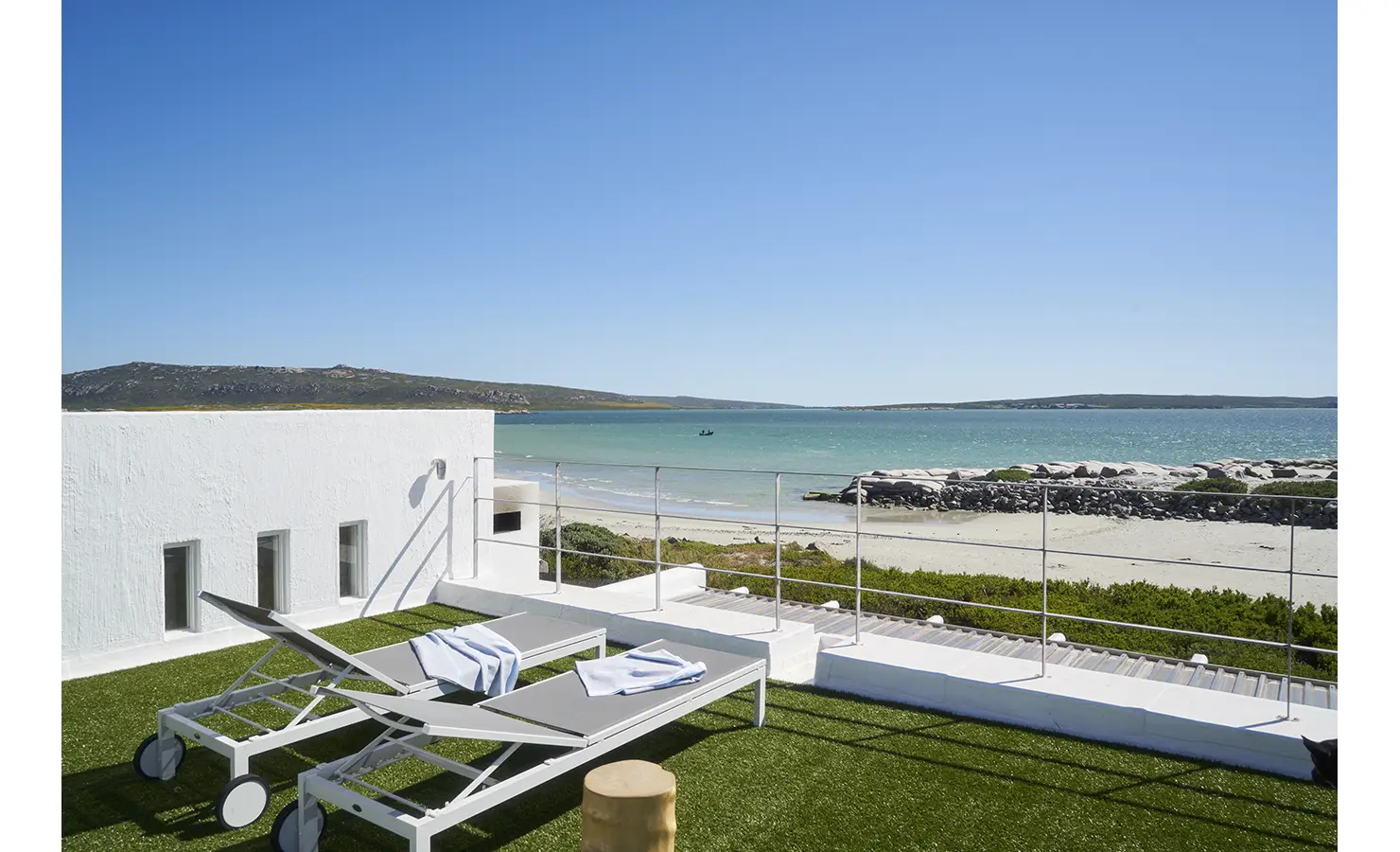 Perfect Hideaways: A stunning rooftop terrace with two sun loungers overlooking the turquoise waters and sandy shores of the lagoon, offering a perfect seaside escape. Blue Lagoon, Langebaan.