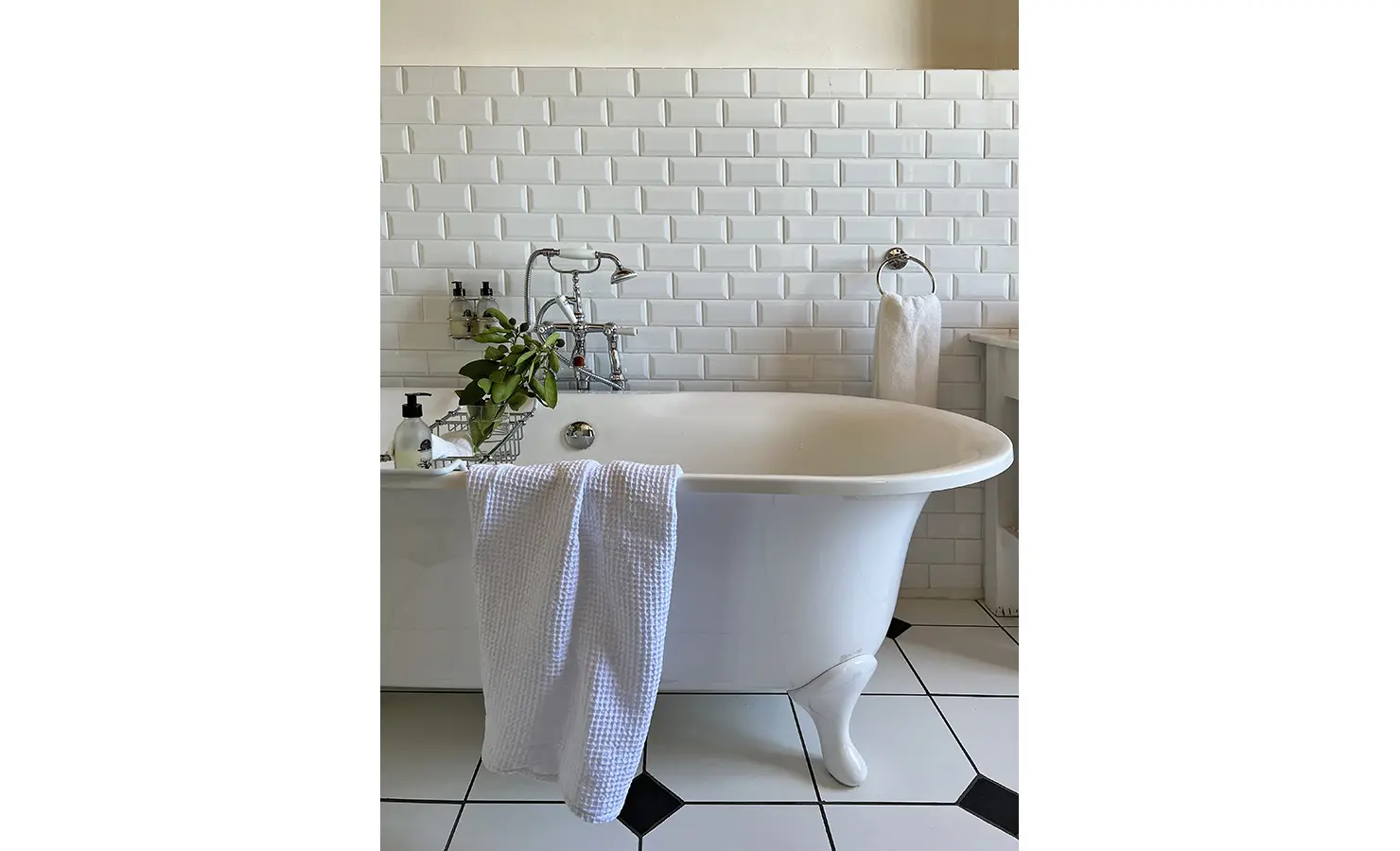 Perfect Hideaways: A classic freestanding bathtub with chrome fittings and soft towels, set against a backdrop of white subway tiles. Penhill Manor House, Nuy Valley.