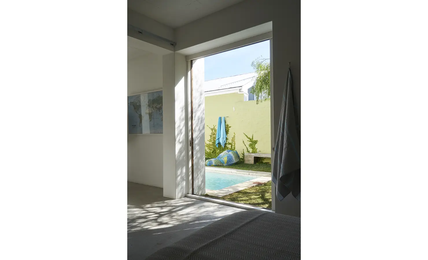 Perfect Hideaways: A peaceful bedroom view leading to the garden, where a sunlit pool and vibrant greenery create a private oasis just steps away. Blue Lagoon, Langebaan.
