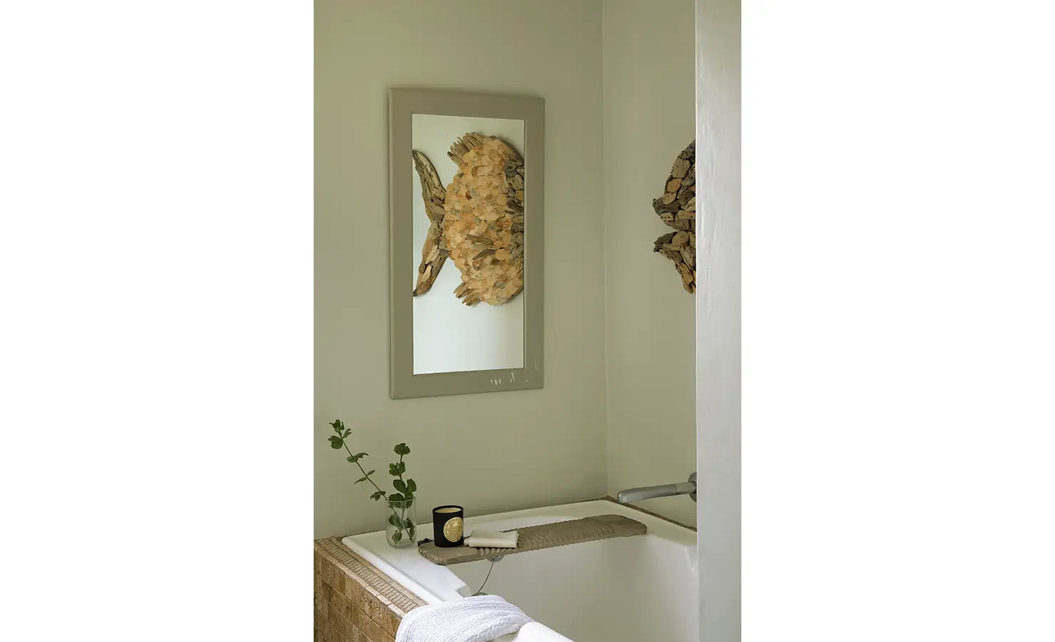 Perfect Hideaways: A tranquil bathtub scene framed by coastal-inspired decor, including a fish-shaped driftwood sculpture reflected in a mirror, and greenery placed in glass vases. Churchhaven, Fynbos.