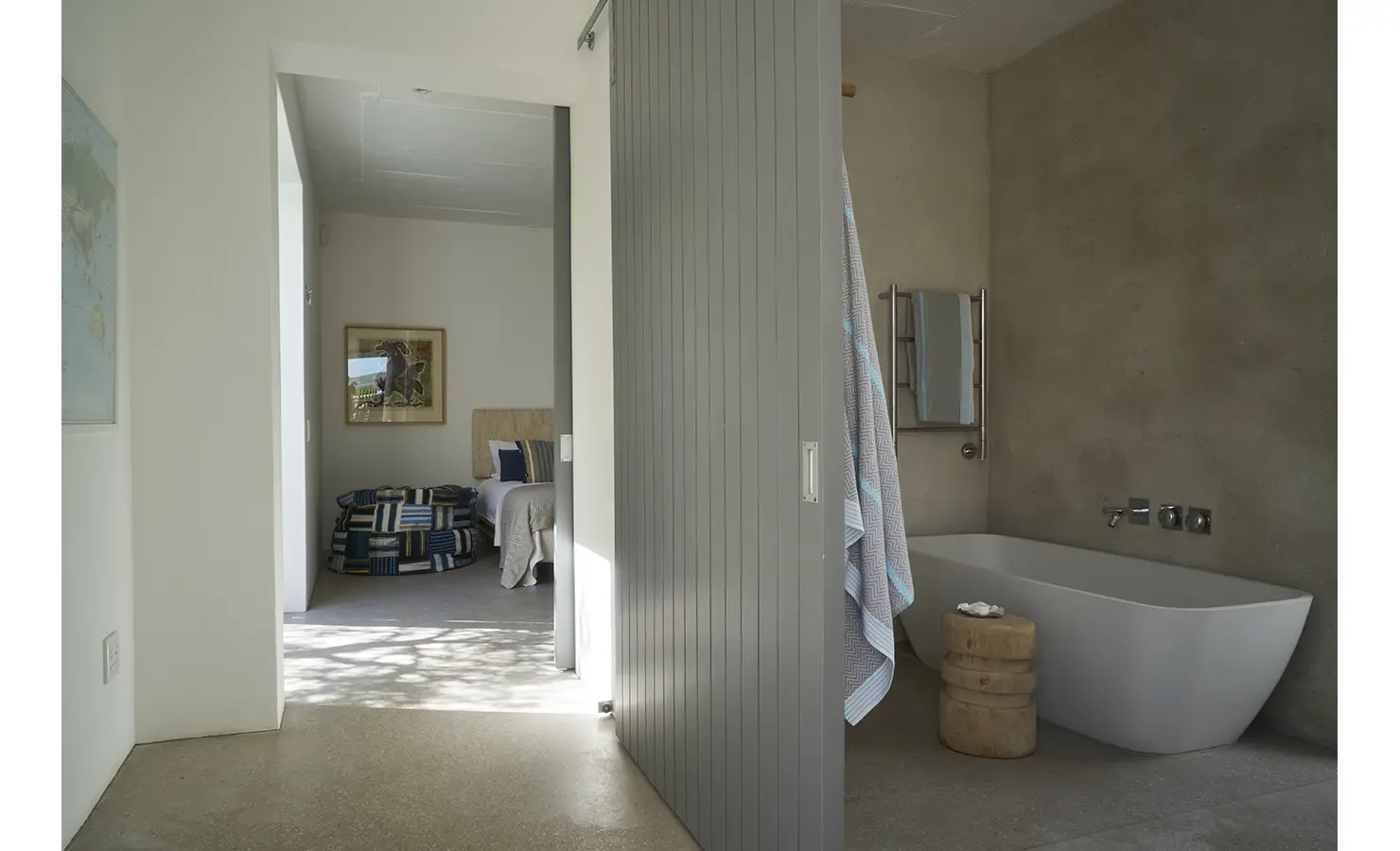 Perfect Hideaways: A modern open-plan bedroom and bathroom space featuring a deep soaking tub, soft natural lighting, and contemporary coastal decor. Blue Lagoon, Langebaan.