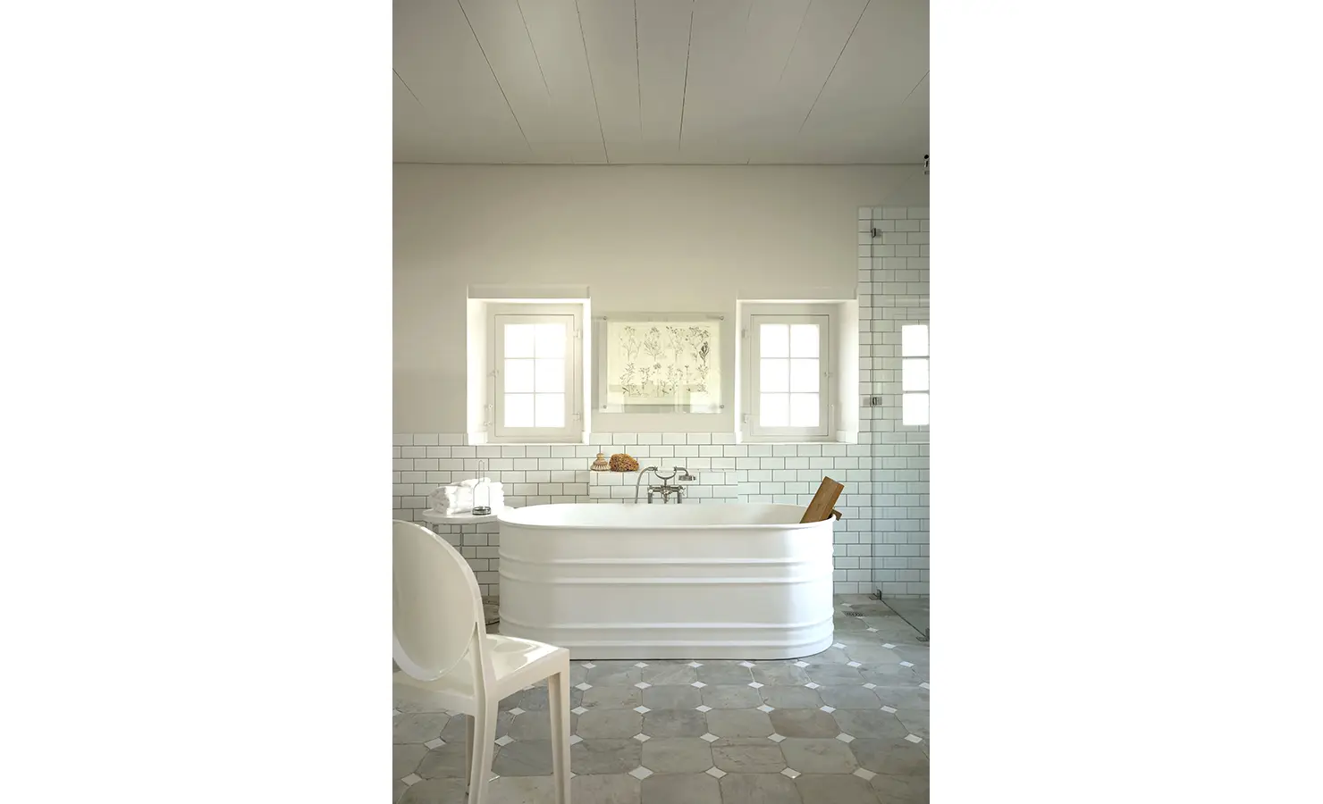 Perfect Hideaways: A tranquil bathroom with a deep soaking tub, subway-tiled walls, and soft natural light filtering through classic sash windows, evoking timeless sophistication. Babylonstoren, Franschhoek.