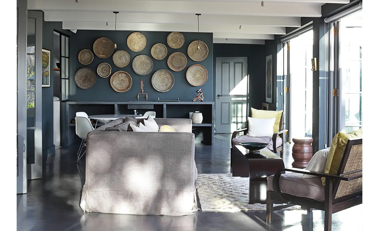 Indoor lounge space with decorative baskets on bright blue wall. Koko House.