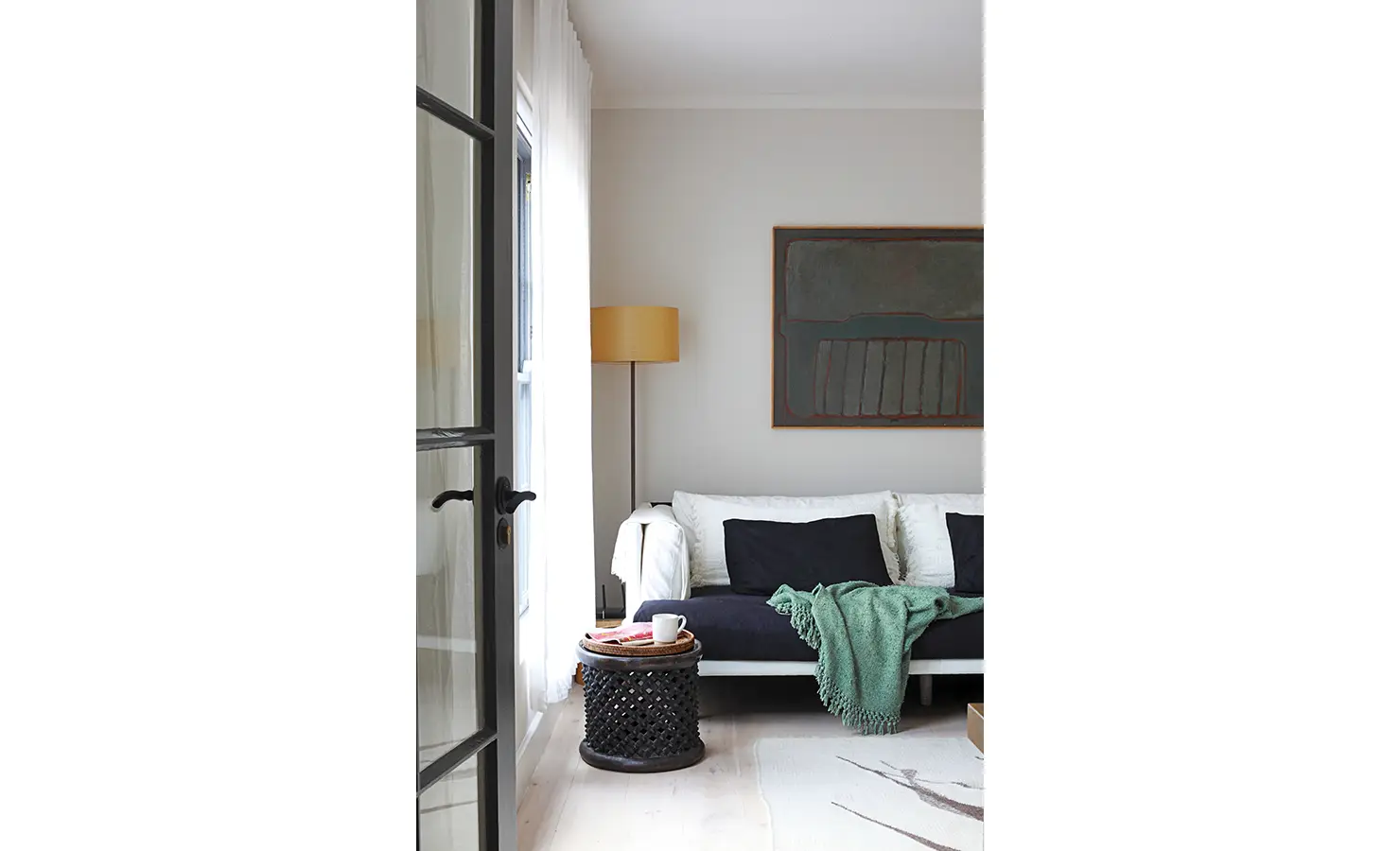 Cozy seated area with blue and white couch and contemporary moody artwork. Koko House.