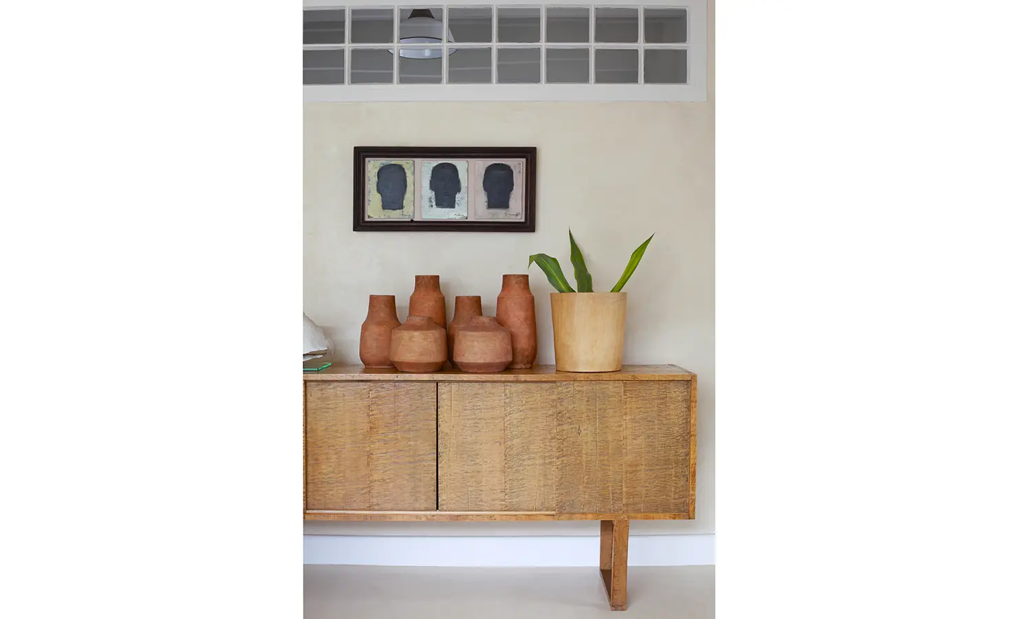Simple wooden console showcasing terracotta ceramics and pot plant. Koko House.