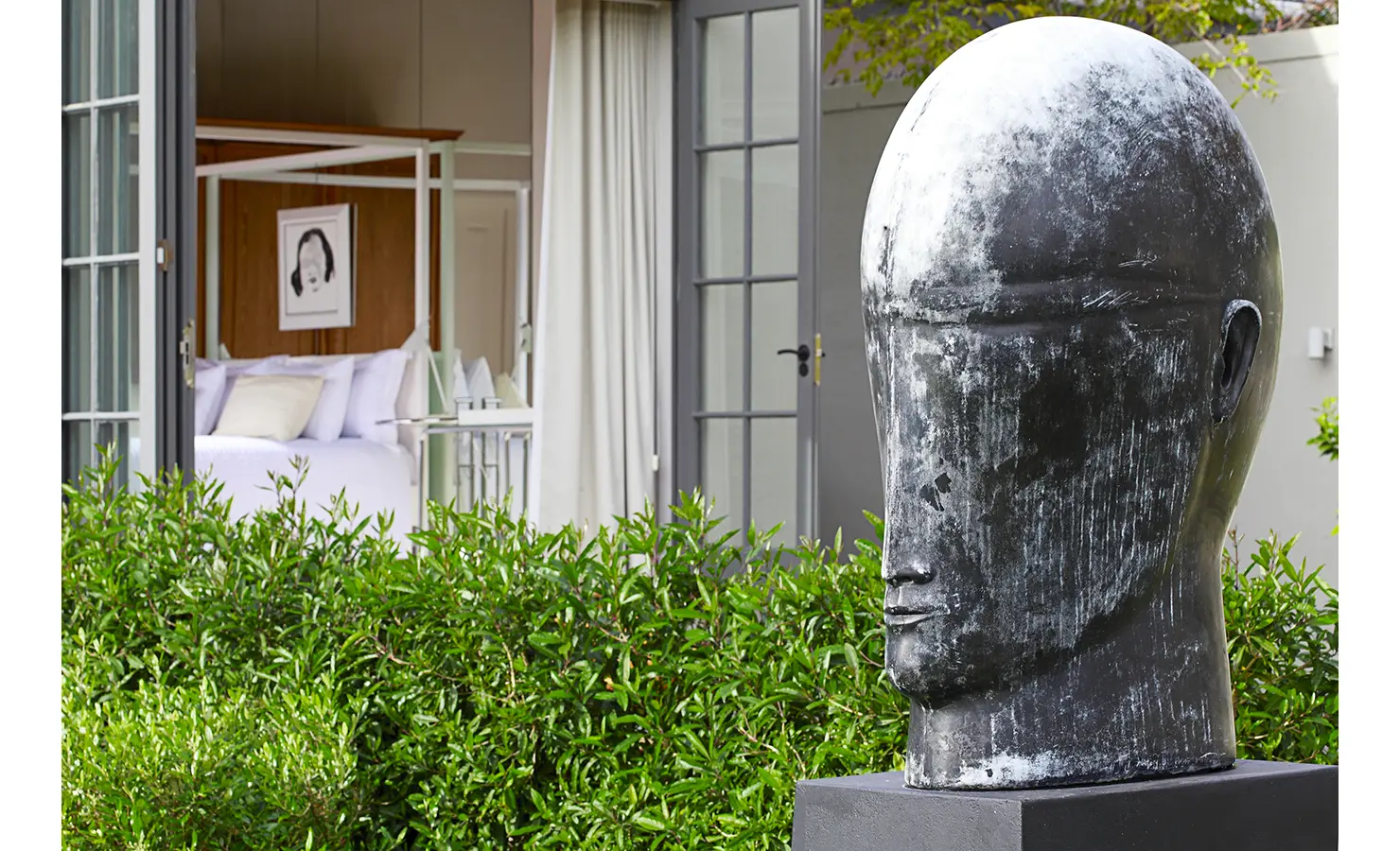 Large garden sculpture of human face. Koko House.