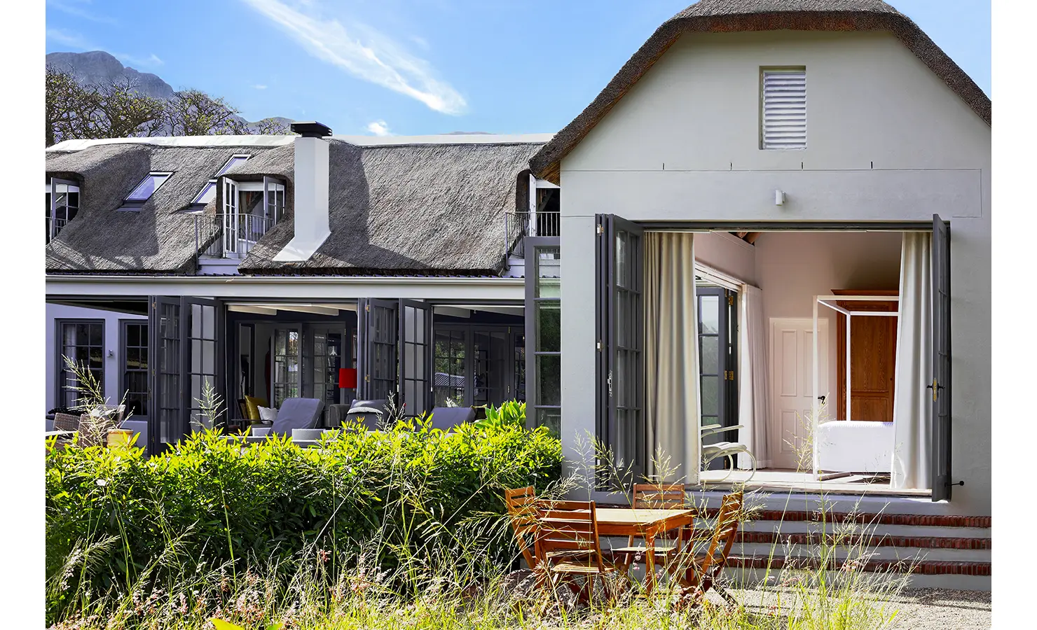 View of thatch manor farmhouse and patio with Koko House.