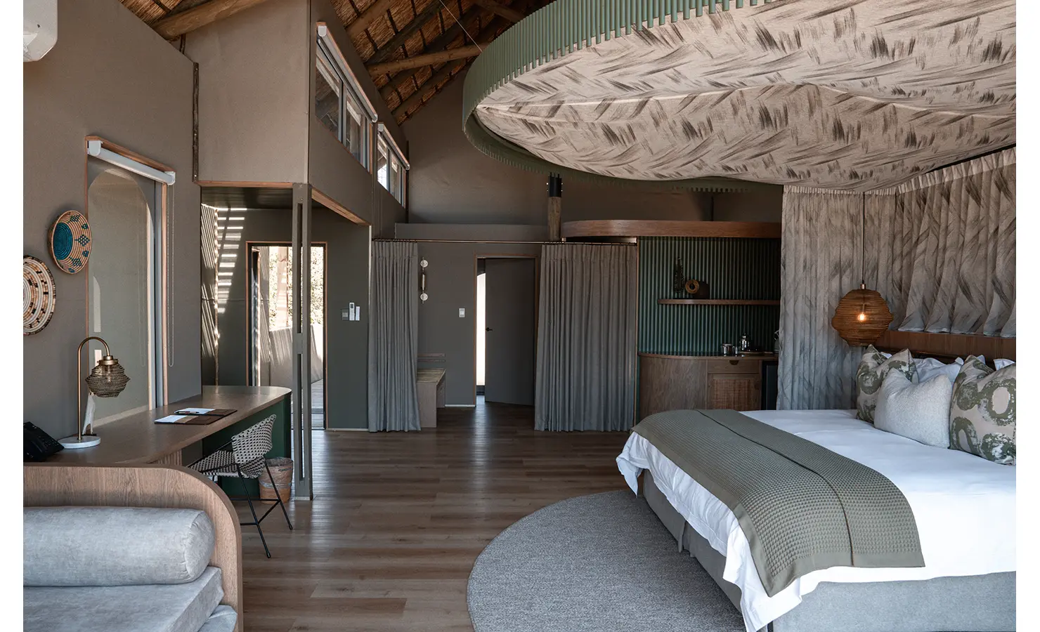 Perfect Hideaways: A stylish safari suite with earthy tones, intricate woven textures, and a statement ceiling, combining contemporary design with natural elements for a luxurious retreat. Victoria Falls River Lodge, Zambezi National Park.