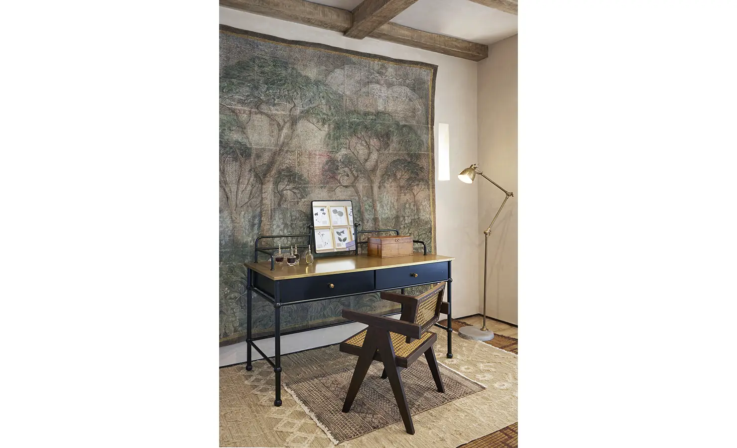 Perfect Hideaways: A charming workspace with a vintage desk and chair, a floor lamp, and a decorative tapestry featuring a forest motif. Kubili House, Thornybush Game Reserve.