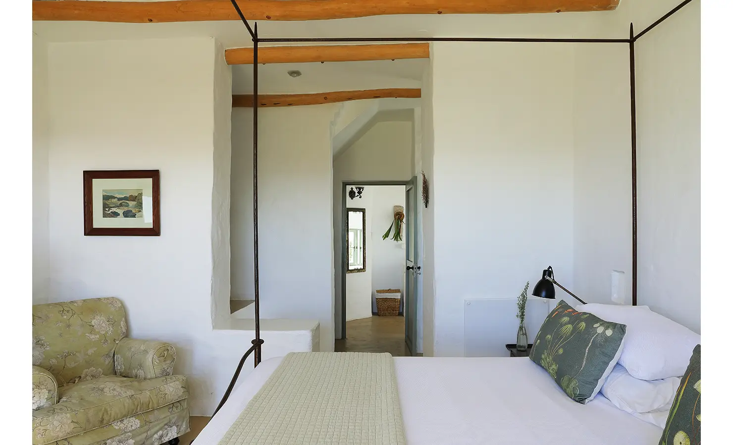 Perfect Hideaways: A bedroom with a canopy bed, botanical-themed cushions, and an upholstered armchair, exuding a blend of comfort and elegance. Farniente, Kommetjie.
