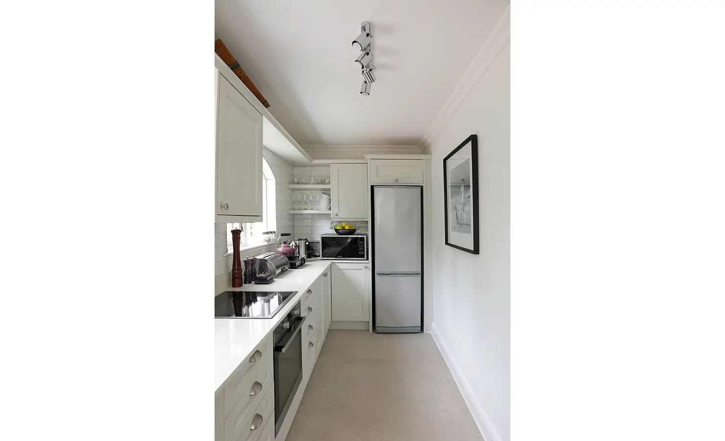 Perfect Hideaways: A charming country-style kitchen with white cabinetry, open shelving, and modern appliances, designed for both functionality and elegance. Buitenzorg Estate, Constantia.