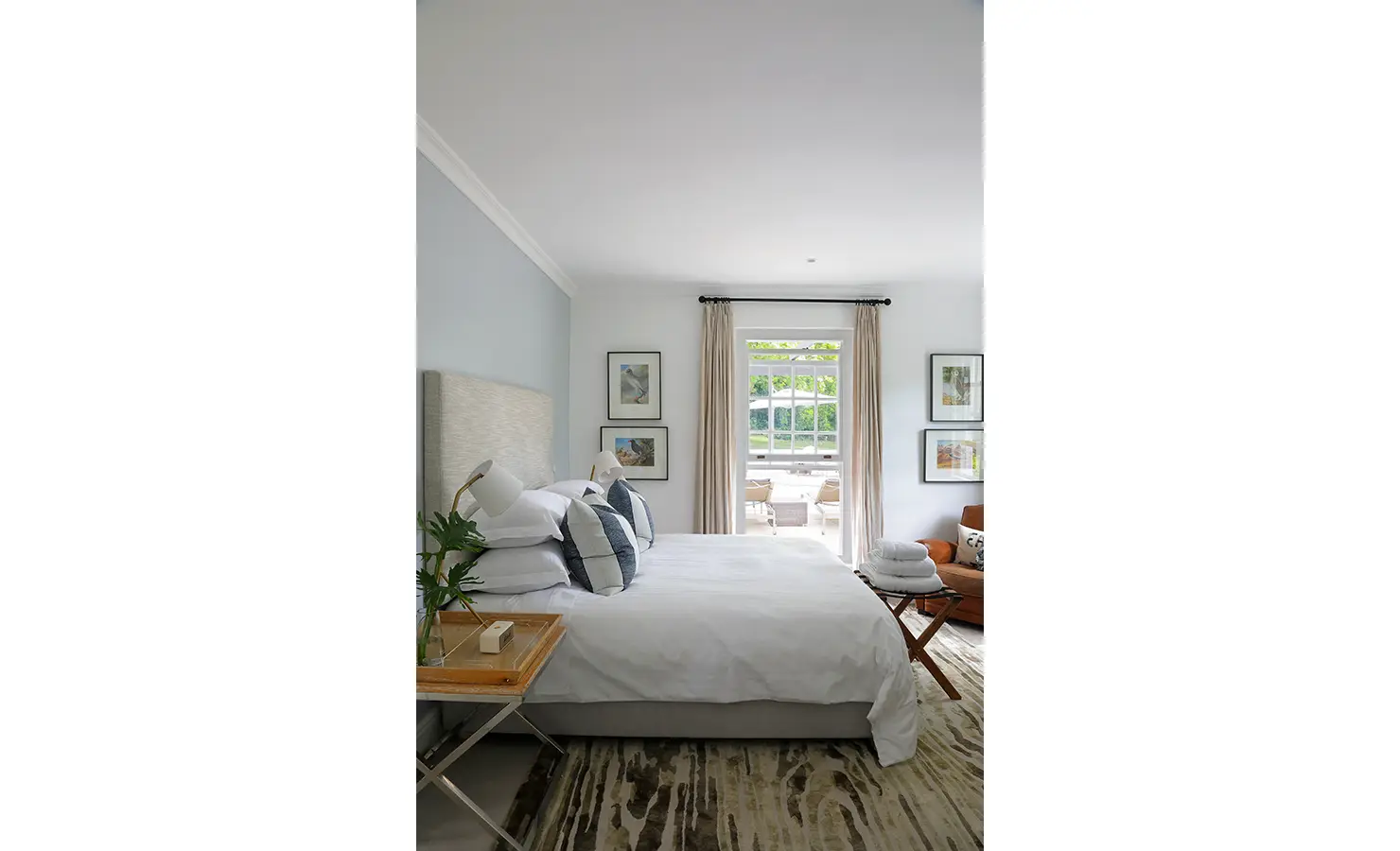 Perfect Hideaways: A tranquil bedroom with a plush bed, elegant décor, and a doorway leading to a sunlit patio, creating a seamless indoor-outdoor flow. Buitenzorg Estate, Constantia.