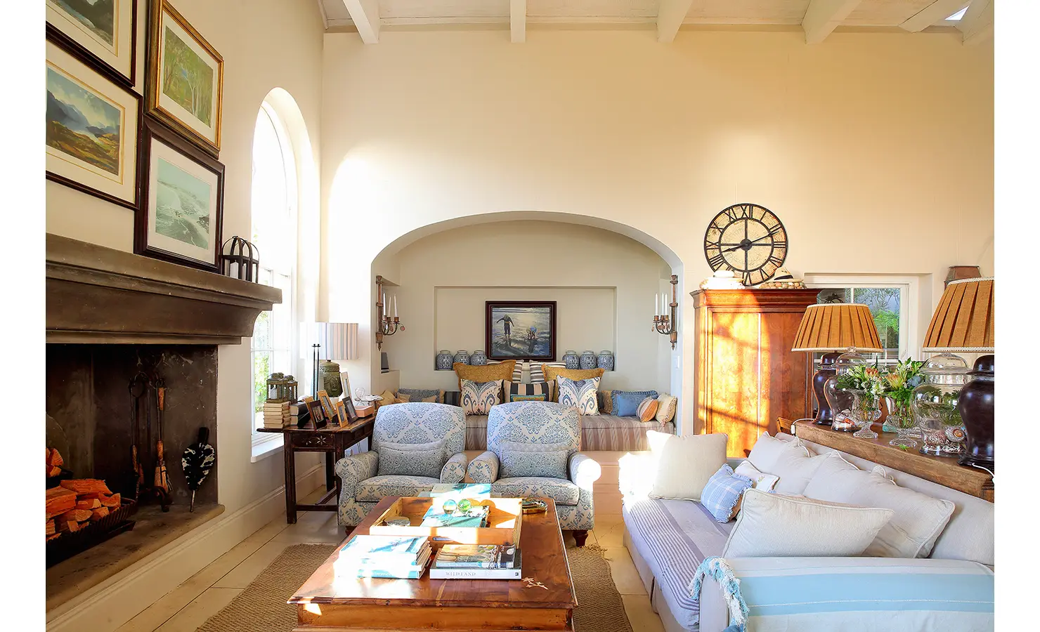Perfect Hideaways: An elegant indoor lounge with a large fireplace, soft armchairs, and a daybed accented by artistic decor and soft lighting. Beachwood On Robberg, Plettenberg Bay.