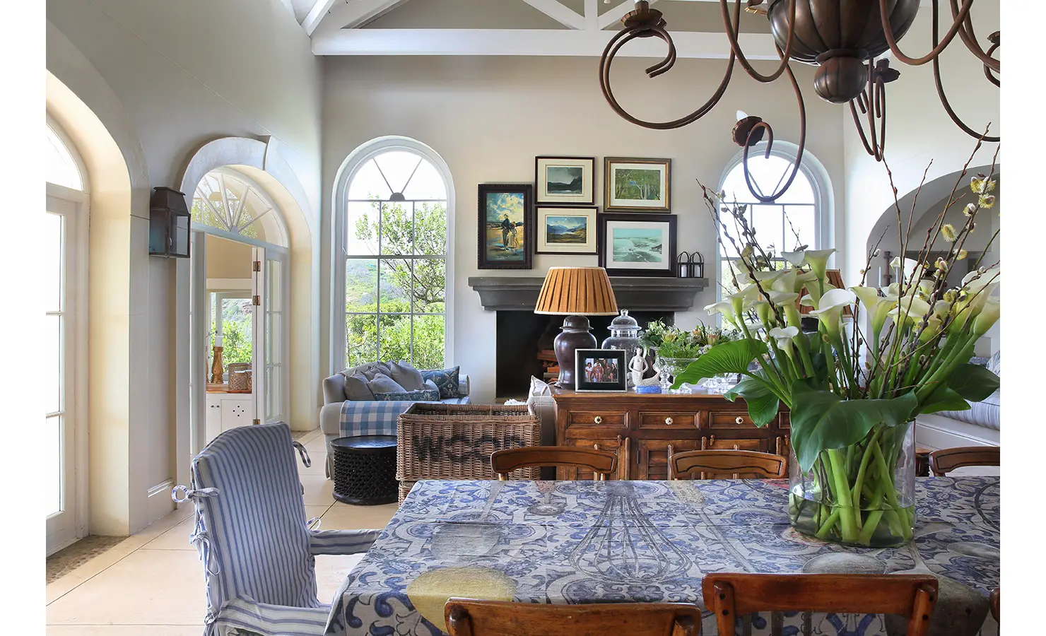 Perfect Hideaways: A beautifully decorated dining area with a large table covered in a patterned cloth, fresh flowers as a centrepiece, and an open view of the surrounding greenery. Beachwood On Robberg, Plettenberg Bay.