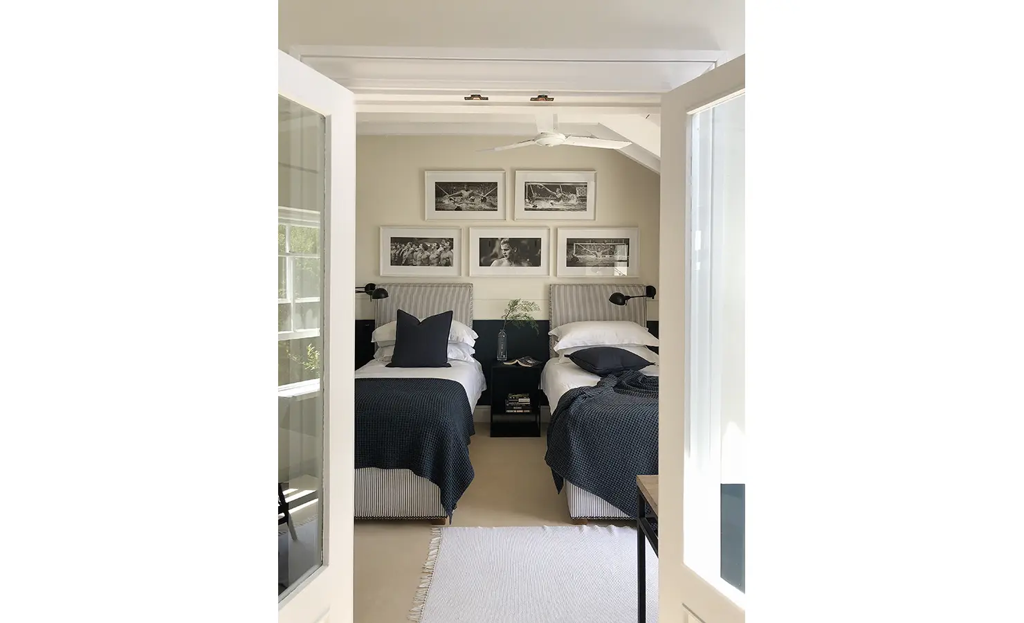 Perfect Hideaways: A glimpse into a twin bedroom through French doors, showcasing neatly made beds with navy accents and a tasteful, minimalist design. Beachwood On Robberg, Plettenberg Bay.