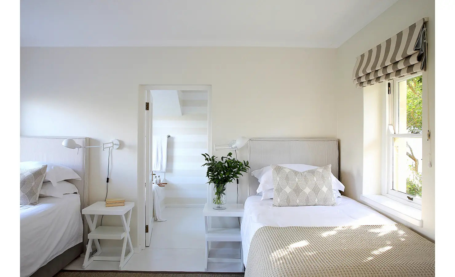 Perfect Hideaways: A bright twin bedroom with a minimalist design, featuring neutral tones, striped blinds, and an ensuite bathroom. Beachwood On Robberg, Plettenberg Bay.