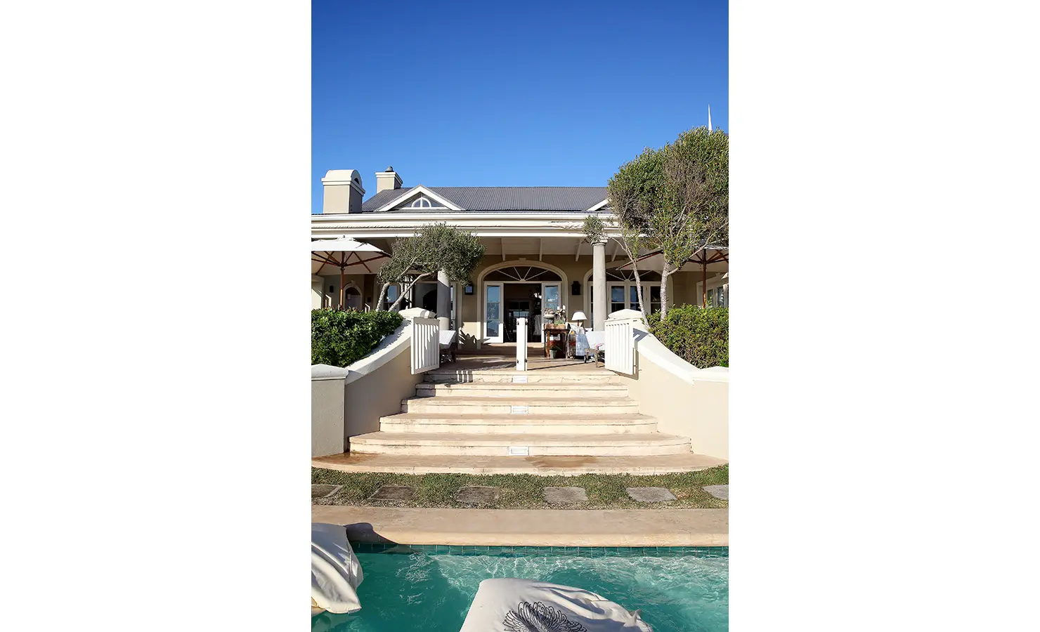 Perfect Hideaways: A grand exterior view of the property, showcasing steps leading up to a covered patio and lush greenery. Beachwood On Robberg, Plettenberg Bay.