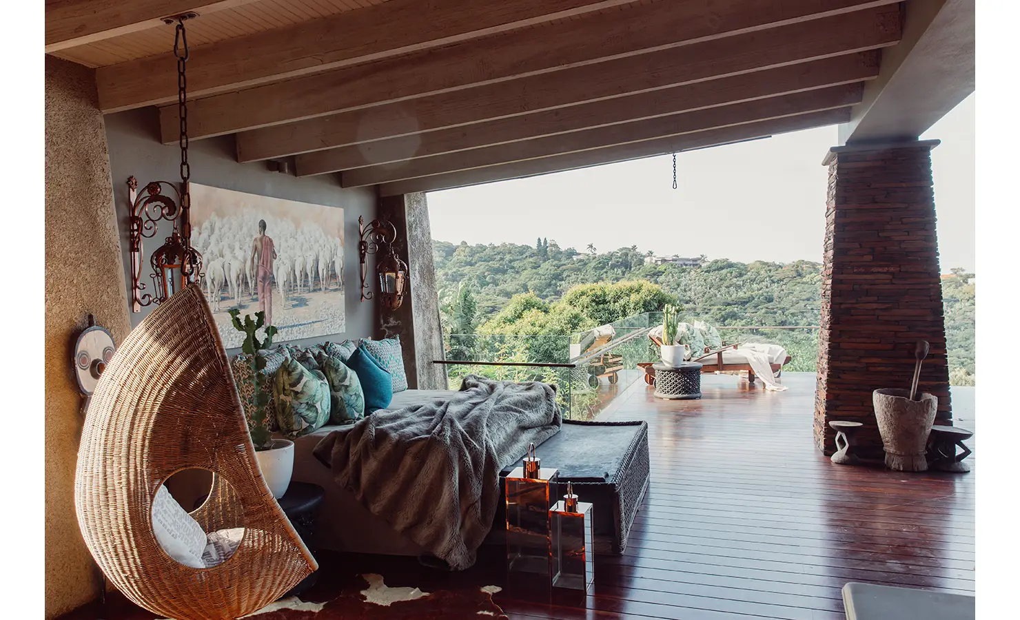 Perfect Hideaways: An elevated outdoor sanctuary with a covered terrace, cozy daybed, and hanging wicker chair, overlooking a canopy of greenery. The space exudes warmth with natural textures and earthy tones, perfect for peaceful relaxation. Sophias Retreat, Durban North.