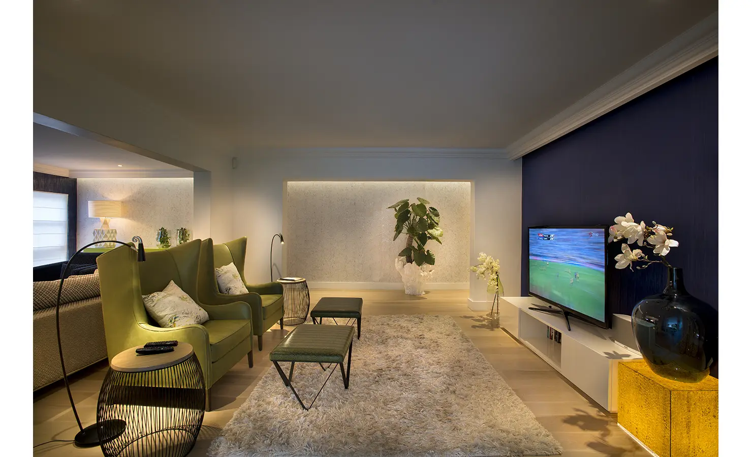 Perfect Hideaways: A cosy TV lounge showcases lime-green wingback chairs, a plush rug, and contemporary lighting, creating a warm and inviting space. AtholPlace Hotel & Villa, Atholl.