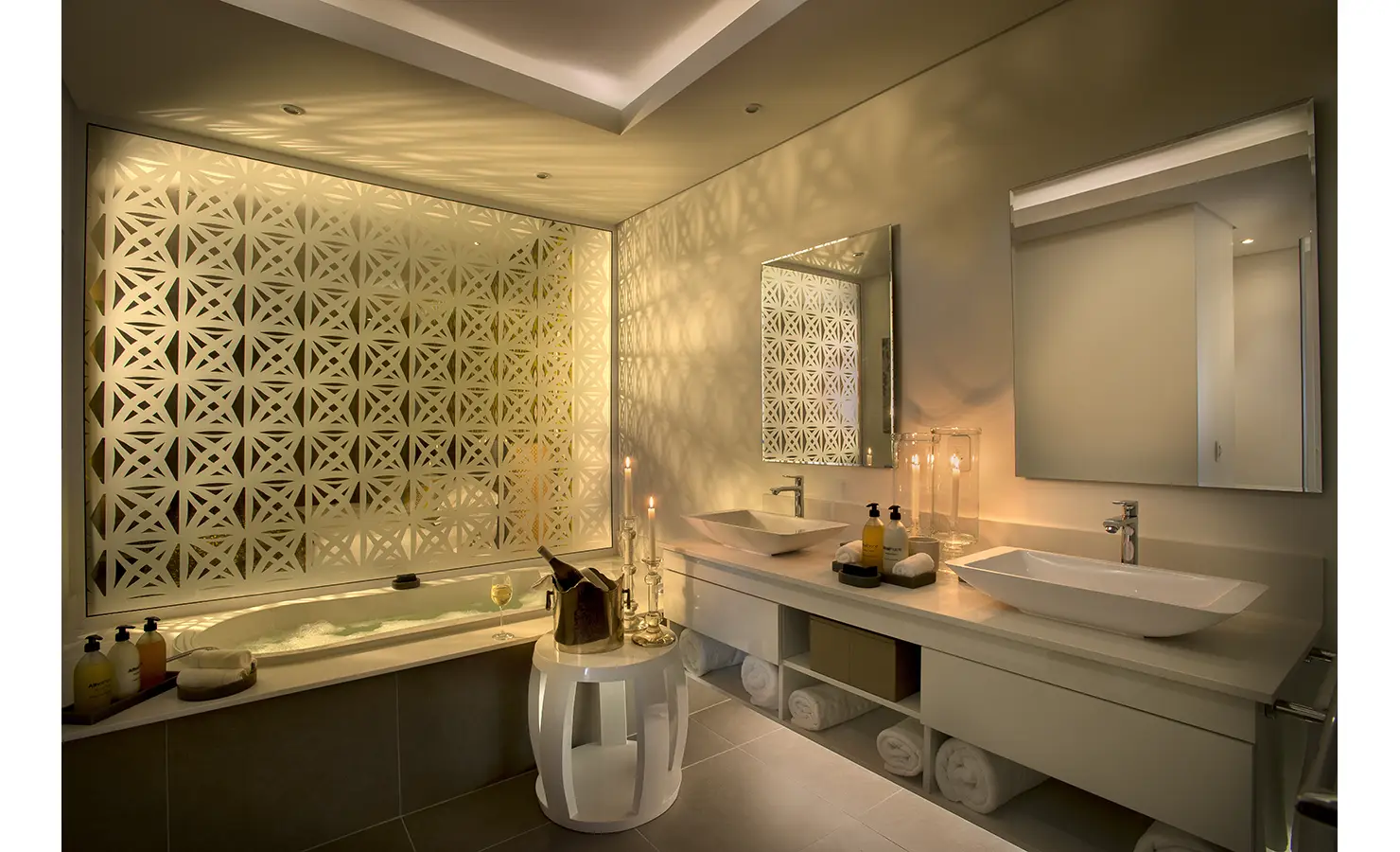 Perfect Hideaways: A softly lit bathroom combines sleek modernity with indulgence, featuring a large soaking tub, geometric screen, and double vanity with elegant accessories. AtholPlace Hotel & Villa, Atholl.