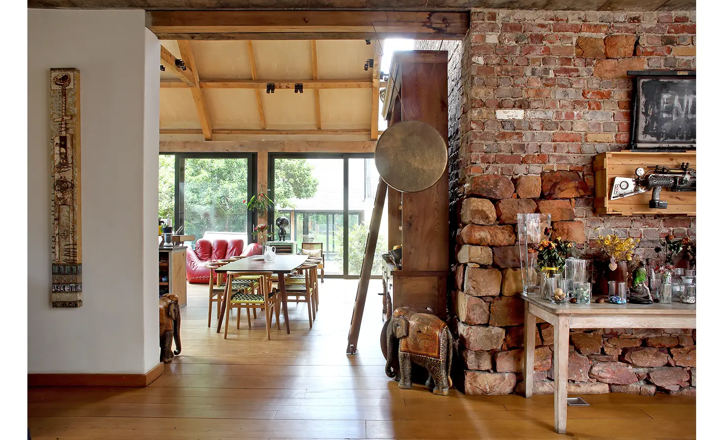 Perfect Hideaways. An elegant living room with a charming brick wall and rich wooden floors, offering a warm and welcoming environment. Gaia, Constantia.