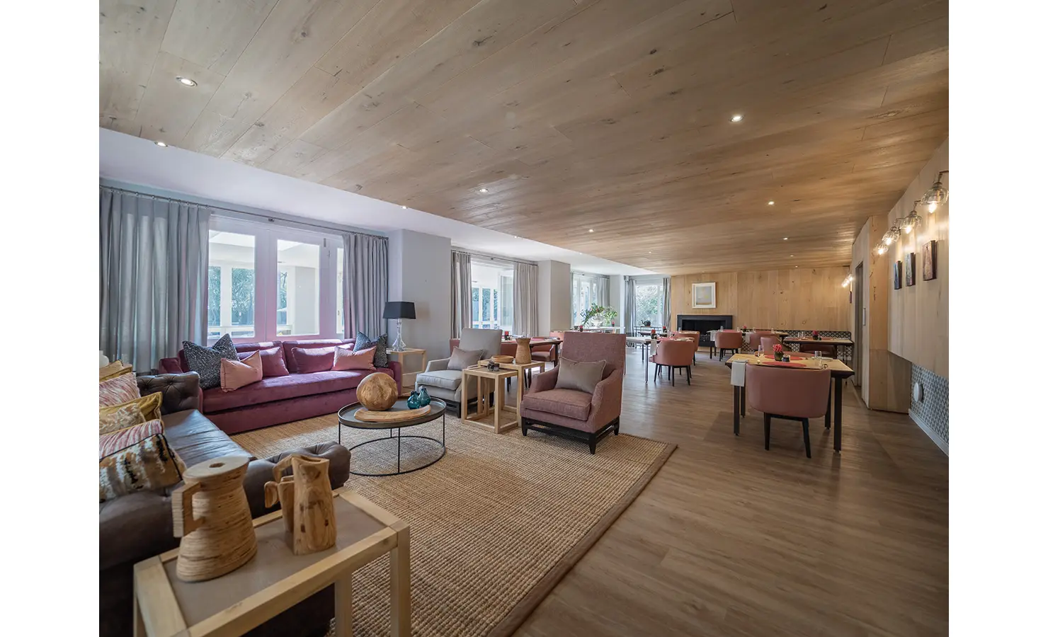 Perfect Hideaways: A vast open-plan living and dining space features blush-toned armchairs, a velvet sofa, and light timber finishes, creating a welcoming, contemporary interior. AtholPlace Hotel & Villa, Atholl.