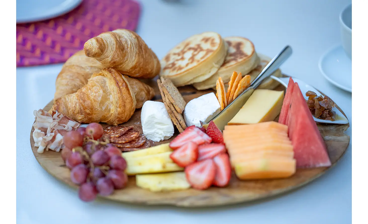 Perfect Hideaways: A beautifully styled breakfast board overflows with fresh croissants, soft cheeses, cured meats, fruit, and crackers, ideal for a gourmet morning start. AtholPlace Hotel & Villa, Atholl.