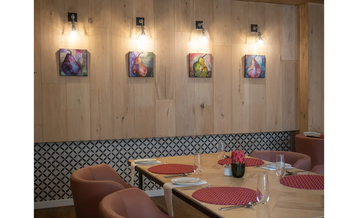 Perfect Hideaways: An intimate dining nook is artfully styled with modern pendant lights, wooden wall panelling, and colourful still-life paintings, enhancing its characterful charm. AtholPlace Hotel & Villa, Atholl.