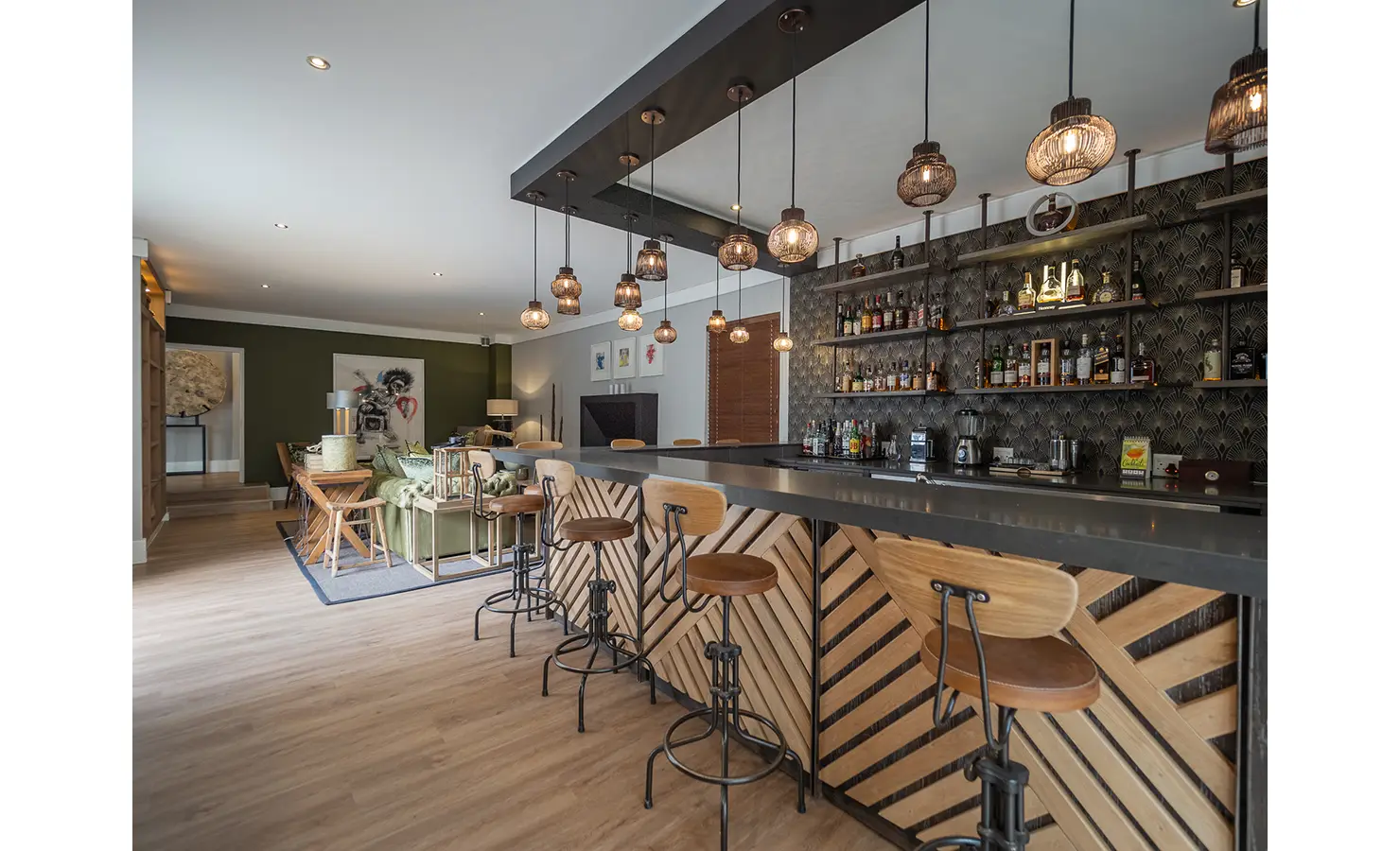 Perfect Hideaways: A chic bar with wooden stools and a mirrored ceiling is backed by an eclectic collection of spirits, artisanal glassware, and bold wallpaper. AtholPlace Hotel & Villa, Atholl.