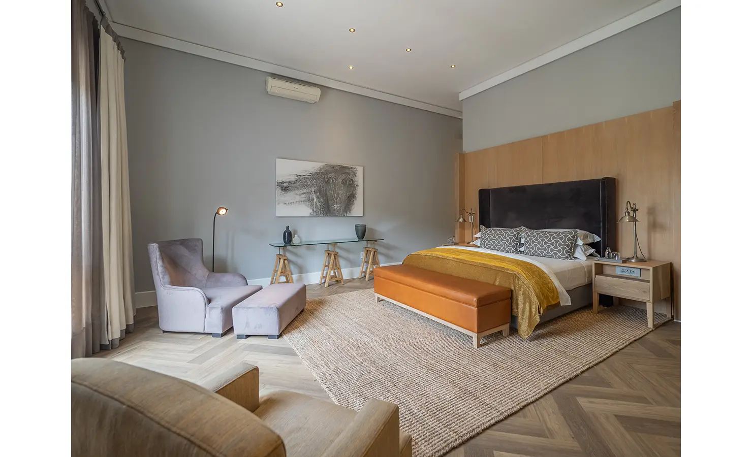 Perfect Hideaways: A spacious suite balances simplicity and comfort with pale grey walls, layered textures, and mustard accents against timber and glass details. AtholPlace Hotel & Villa, Atholl.