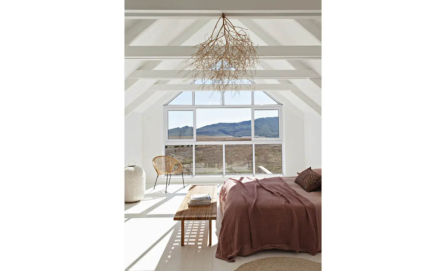 Perfect Hideaways: Sunlit loft bedroom with vaulted ceiling, earthy terracotta bedding, and panoramic mountain views through large windows, Thuúla Haven, Hemel-en-Aarde.