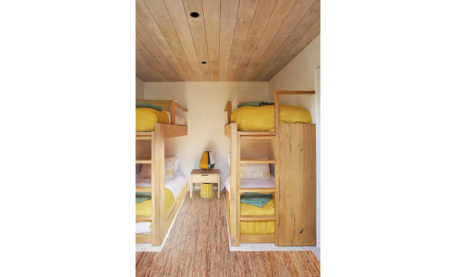 Perfect Hideaways: A cosy bunk bedroom with handcrafted wooden beds, bright yellow bedding, and natural woven textures, creating a warm and inviting retreat for guests. Flamingo, Churchhaven.