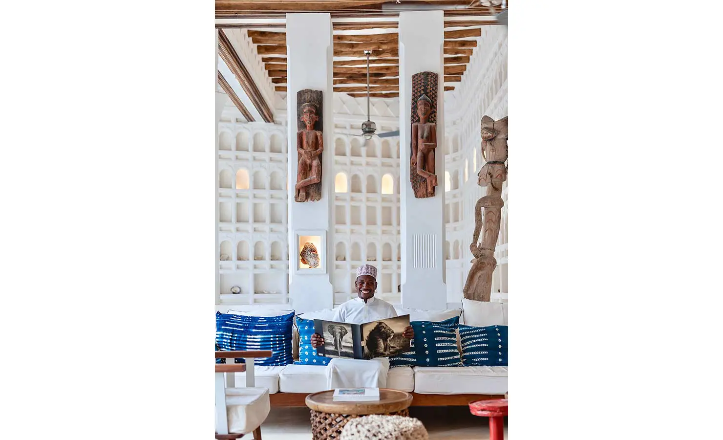 Perfect Hideaways: A traditional-style lounge with detailed wall niches, wooden sculptures, and comfortable seating adorned with blue cushions, creating a serene atmosphere. The Kasbah, Lamu.
