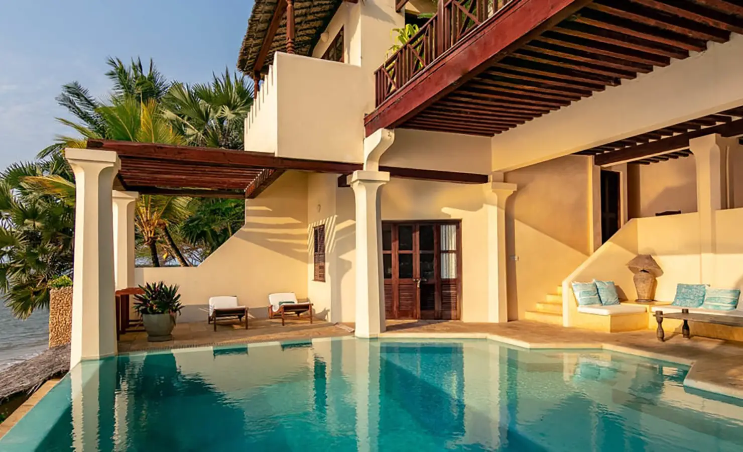 Perfect Hideaways: A serene villa with an infinity pool, wooden pergolas, and tropical palm trees, overlooking the ocean. Shela Beach House, Lamu.
