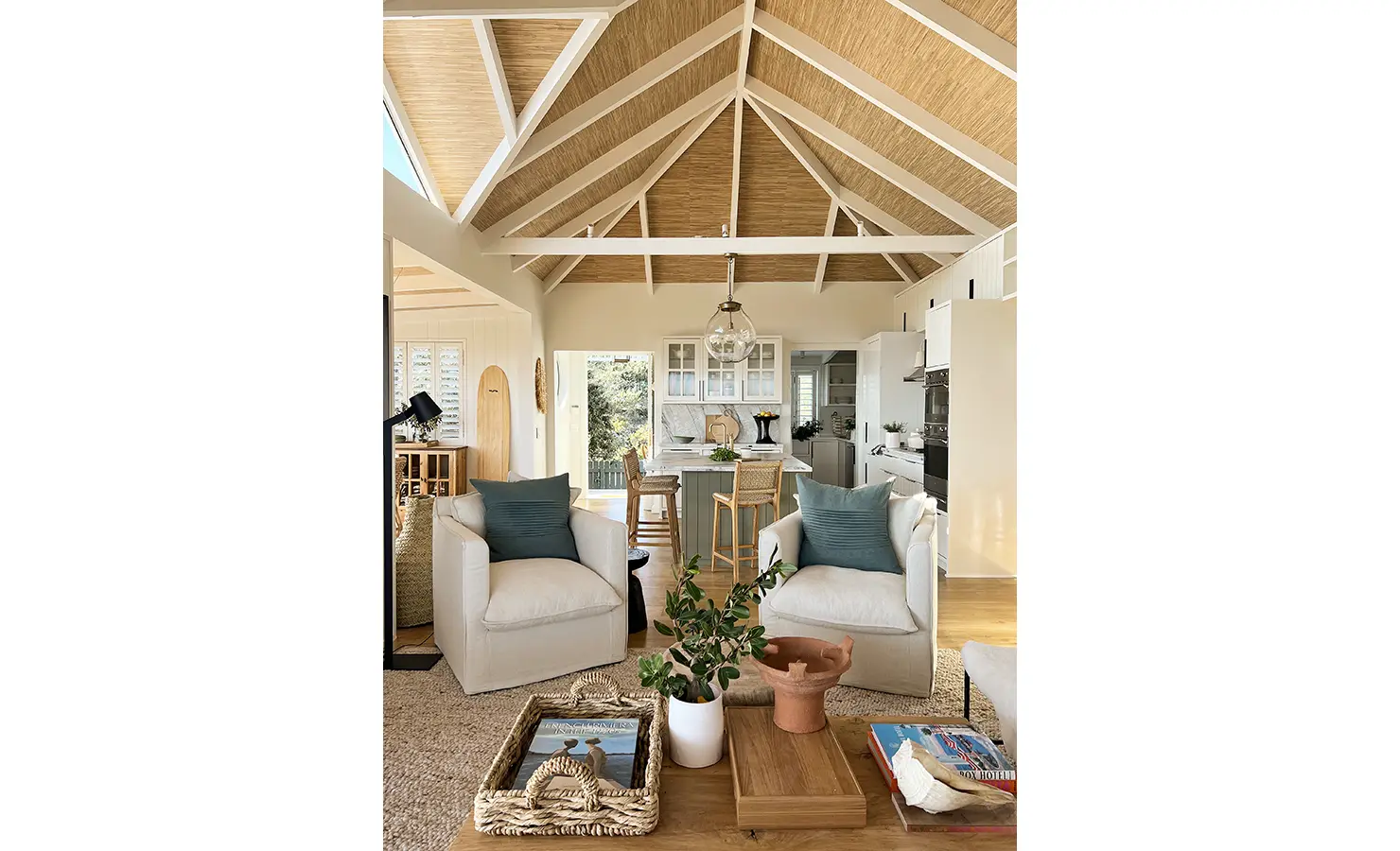 Perfect Hideaways: A beautifully styled open-plan living area with exposed beams, a marble kitchen island, and elegant furnishings. Muted coastal hues and organic textures enhance the relaxed yet sophisticated atmosphere. Sunset Cove, Kommetjie.