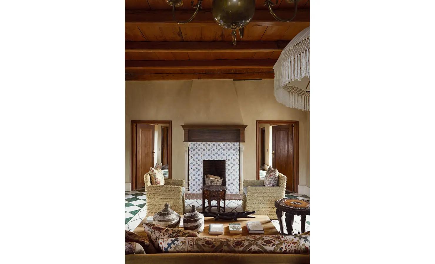 Perfect Hideaways: A cosy seating arrangement in front of a fireplace, adorned with a tiled mantle and woven chairs, offering a warm and inviting atmosphere. Sterrekopje, Franschhoek.