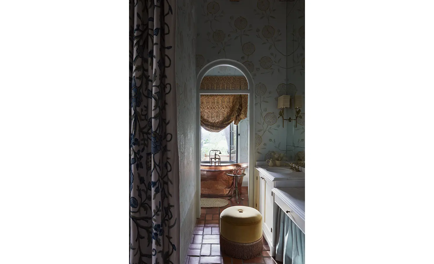Perfect Hideaways: A bathroom corridor leading to a copper bathtub, framed by floral-patterned wallpaper and soft lighting. Sterrekopje, Franschhoek.