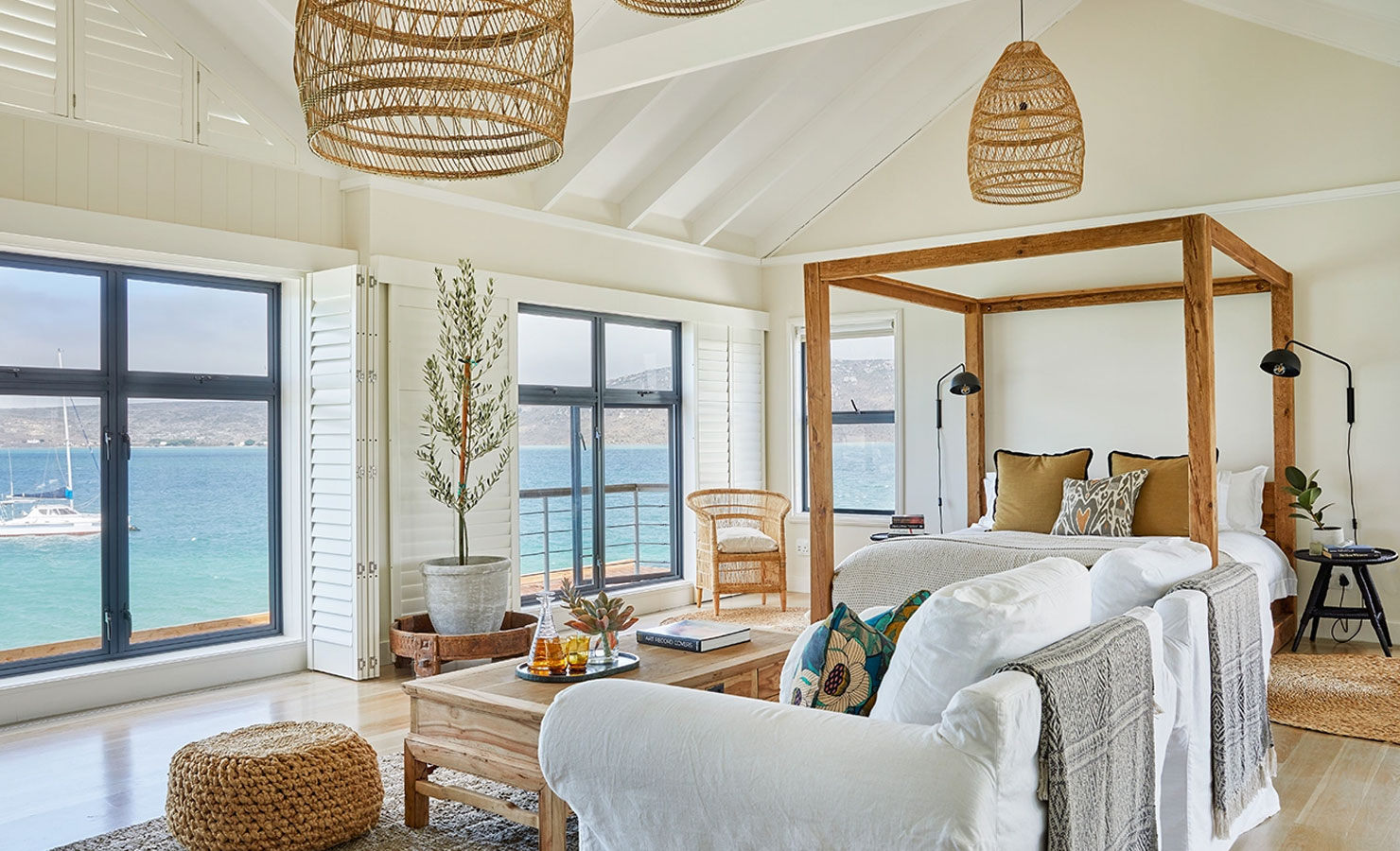 Boats bob below the peaceful bedroom at Frailann, a serene beach house in Langebaan.