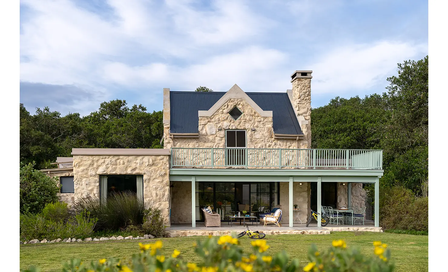 Perfect Hideaways: Gabled stone house with charcoal roof, mint balustrades and a deep veranda opening onto lawns edged by fynbos, Stanford, Coot Club.