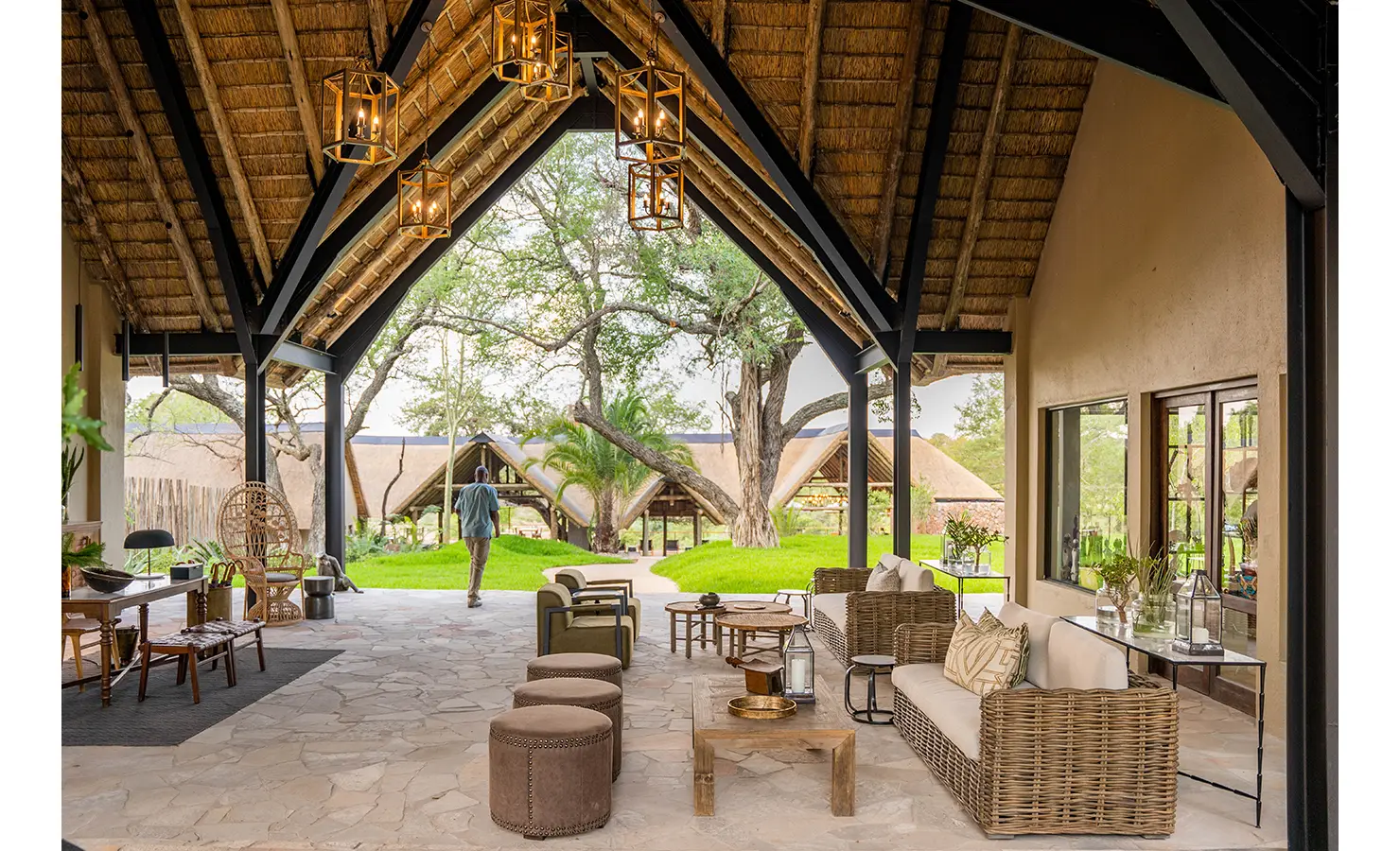 Perfect Hideaways: A closer look at the lodge’s pool area, where woven loungers and shaded seating create a tranquil atmosphere. Towering trees provide a natural canopy, enhancing the sense of privacy and connection to nature. Thornybush Lodge, Thornybush Game Reserve.