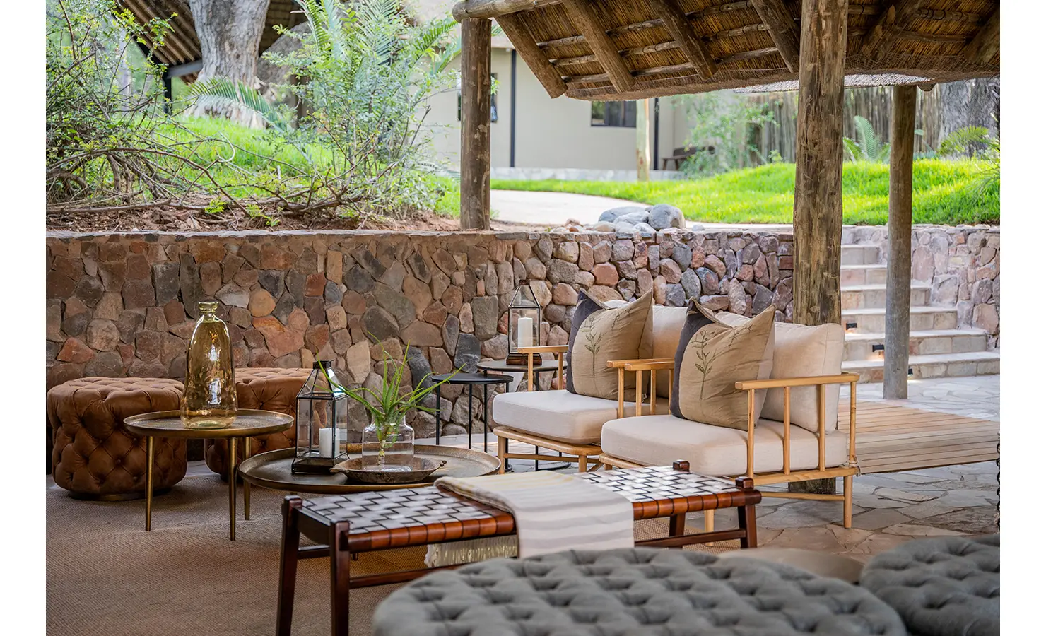 Perfect Hideaways: A relaxed, shaded seating area on an expansive wooden deck, offering a perfect vantage point over the surrounding bushveld. Elegant parasols and wicker loungers provide an idyllic space for unwinding in the wild. Thornybush Lodge, Thornybush Game Reserve.