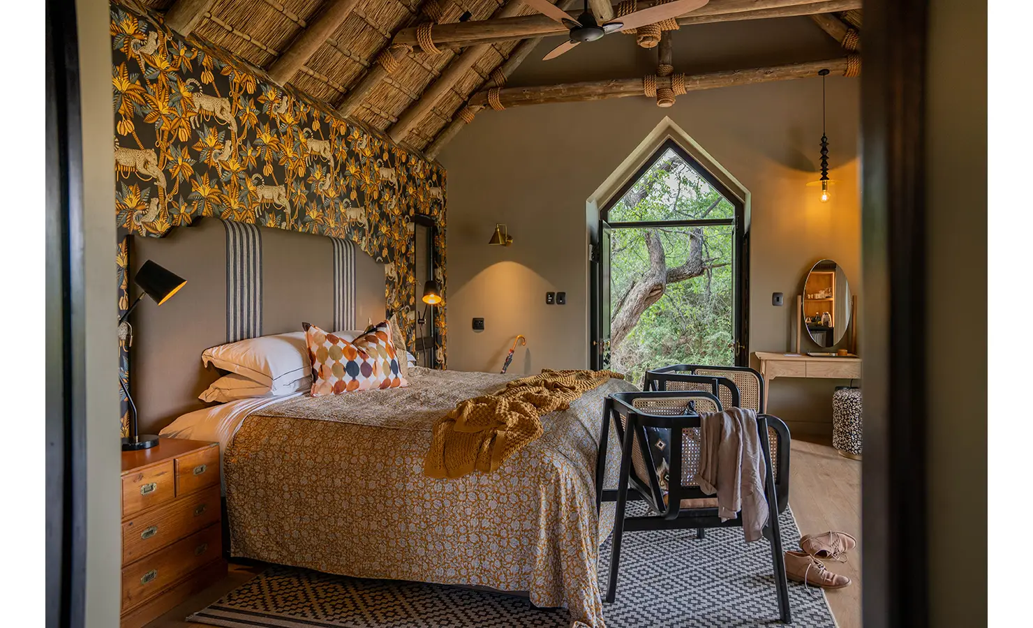 Perfect Hideaways: A close-up of the inviting lounge area, featuring rich textures, a stone fireplace, and handcrafted wooden furniture. Warm lighting and earthy tones create a luxurious yet relaxed atmosphere. Thornybush Lodge, Thornybush Game Reserve.