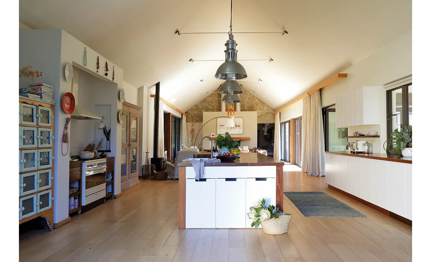 Perfect Hideaways: Spacious kitchen with central island, pendant lighting, and open-plan design flowing into the lounge. Stonehaven House, Hemel-en-Aarde.