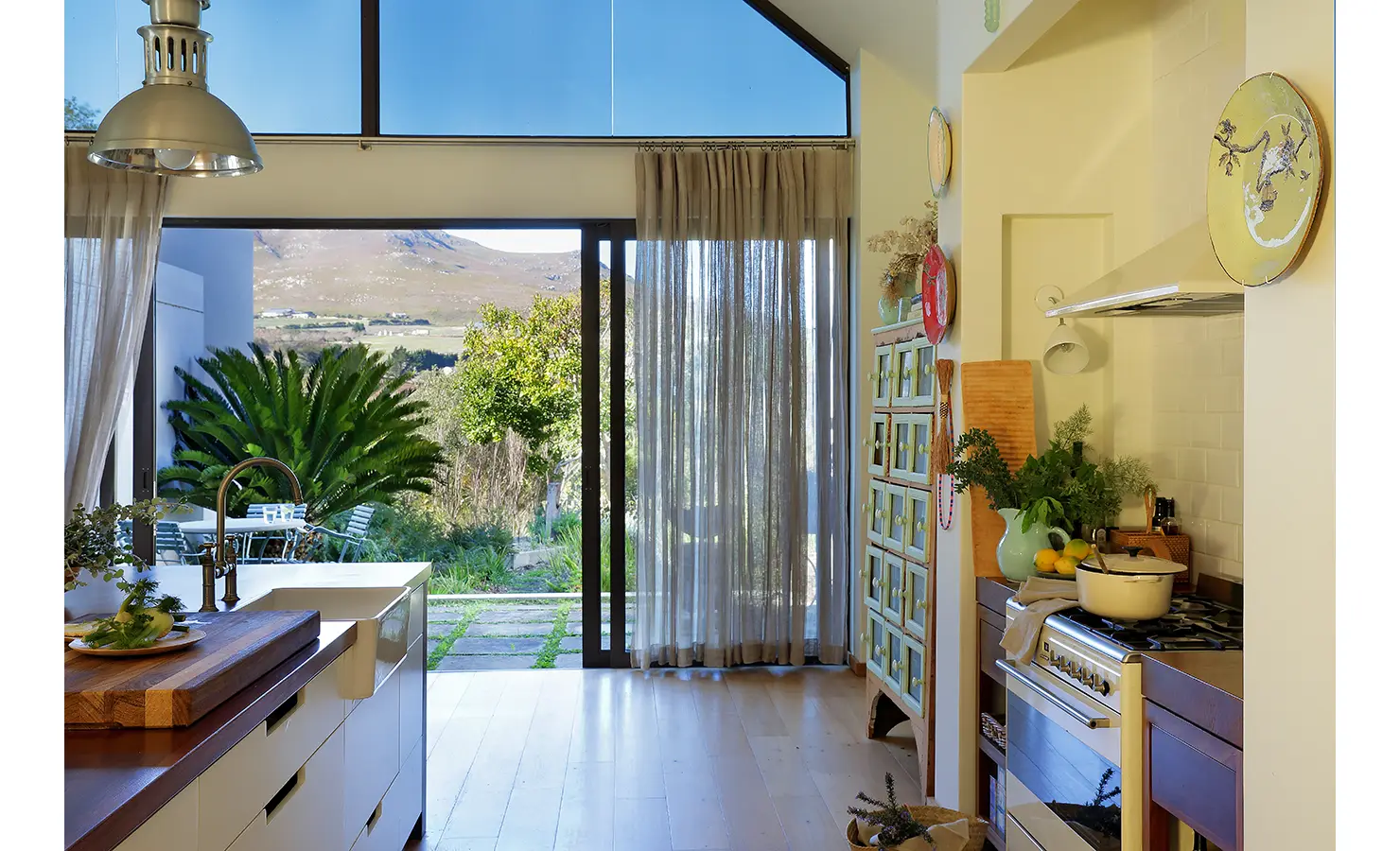 Perfect Hideaways: Kitchen with views of the garden and surrounding hills through large sliding glass doors. Stonehaven House, Hemel-en-Aarde.