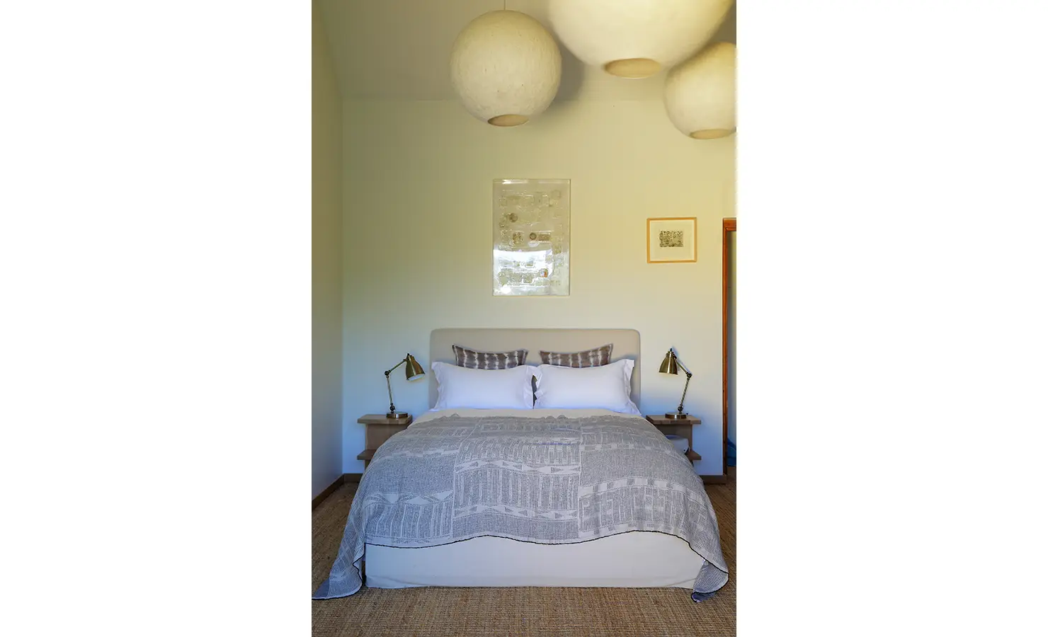 Perfect Hideaways: Simple bedroom with neutral tones, statement pendant lighting, and cosy bed dressed in grey linens. Stonehaven House, Hemel-en-Aarde.
